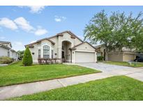 Charming one-story home featuring a manicured lawn and lovely landscaping at 525 Hardwood Cir, Orlando, FL 32828
