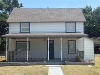 Charming two-story home featuring a covered front porch and a well-maintained lawn at 613 Michigan Ave, St Cloud, FL 34769