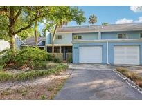 Charming two-story blue townhome with attached garage and mature landscaping at 702 Glasgow Ct, Winter Springs, FL 32708