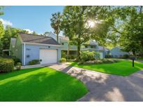 Charming blue two-story home with a well-manicured lawn and attached garage at 702 Glasgow Ct, Winter Springs, FL 32708