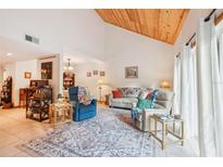 Bright living room features a wood ceiling, neutral walls, and a large rug at 702 Glasgow Ct, Winter Springs, FL 32708