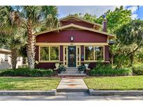 Charming home with a brick exterior, complemented by lush landscaping and a mature palm tree at 806 E Amelia St, Orlando, FL 32803