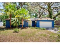 Charming blue brick home with palm trees and a well-manicured lawn at 8619 Veridian Dr, Orlando, FL 32810