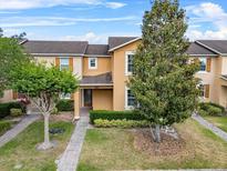 Inviting townhome with well-maintained landscaping, sidewalk, and mature trees in a desirable community at 9009 Savannah Julip Ln, Orlando, FL 32832