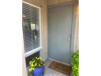 Welcoming front entrance with a charming doormat, window with blinds and a vibrant potted plant at 112 Crown Oaks Way # 112, Longwood, FL 32779
