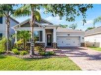 Charming home with a lush landscaped yard, brick pathway, and a two-car garage at 1232 Turnbridge Pl, Oviedo, FL 32765