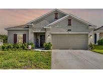 Charming single-story home featuring a two-car garage and inviting front yard landscaping at 1880 Perch Hammock Loop, Groveland, FL 34736
