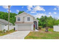 Charming two-story home featuring a well-manicured front yard and attached two-car garage at 232 Oxford Rd, Davenport, FL 33896