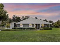 Charming one-story home with landscaped lawn and a well-maintained yard and separate garage at 23203 Outback Ln, Eustis, FL 32736