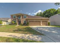 Charming two-story home with a manicured front lawn and a spacious three-car garage at 269 Englenook Dr, Debary, FL 32713