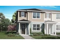 Charming two-story home with tan and blue siding, complemented by a well-maintained green lawn and landscaping at 2823 Camellia Flower St, Apopka, FL 32703