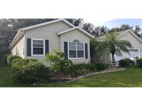 Charming home exterior with lush landscaping, mature trees, and manicured lawn at 3700 Plantation Blvd, Leesburg, FL 34748