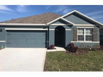 Charming single-Gathering home features a gray exterior, attached garage and manicured lawn at 5067 Tana Ter, St Cloud, FL 34772