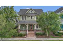 Charming two-story home featuring a welcoming front porch, well-maintained lawn, and mature trees, offering a delightful curb appeal at 8679 Laureate Blvd, Orlando, FL 32827