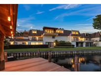 Waterfront property featuring a charming multi-story home with balconies and manicured landscaping at 8988 Houston Pl # 303, Orlando, FL 32819