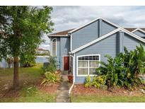 Charming townhome with a blue exterior, mature landscaping, and a welcoming entrance at 135 Orchid Dr, Davenport, FL 33897
