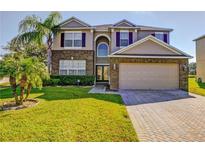Charming two-story home with brick accents, well-manicured lawn, and attached two-car garage at 173 Donner Dr, Winter Garden, FL 34787