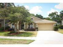 Charming single-story home with mature landscaping, manicured lawn, and a two-car garage at 1937 Crystal Downs Ct, Oviedo, FL 32765