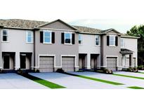 Attractive townhome exteriors with gray paint, single-car garage, black shutters, and manicured landscaping at 2052 Monteverde Ave, Davenport, FL 33837