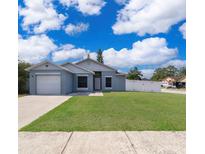 Charming single-story home featuring a well-maintained lawn and a white picket fence at 2164 Rj Cir, Kissimmee, FL 34744
