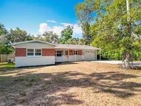 Charming single-story home featuring a brick accent wall, a well-manicured lawn, and an attached garage at 2631 Mcdonald Ter, Mount Dora, FL 32757