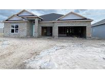 Unfinished exterior of a single-story home with a two-car garage and concrete block construction at 2703 Ravencliffe Ter, Oviedo, FL 32765