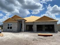 Exterior view of home under construction, showcasing the block structure and roof framework under a cloudy sky at 2703 Ravencliffe Ter, Oviedo, FL 32765