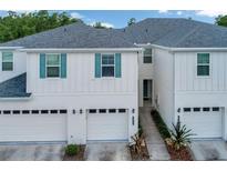 Attractive townhouse with white siding, teal shutters and a one car garage at 2956 Oak Park Way # B, Orlando, FL 32822