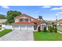 Stunning two-story home with a red tile roof and a three-car garage at 3904 Woodsfield Ct, Orlando, FL 32822