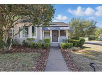 Charming home exterior with a walkway, green shrubs, and a beautiful tree providing shade at 418 W Princeton St, Orlando, FL 32804