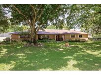 Charming brick home featuring a well-manicured lawn and mature trees providing shade at 429 Kimberly Ct, Sanford, FL 32771