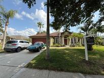 Charming single-story home boasts a well-maintained lawn, mature landscaping, and a welcoming facade at 4920 E Lake Cove Blvd, St Cloud, FL 34771