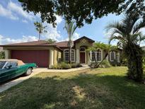Charming single-story home with a well-manicured lawn and mature palm trees, plus an attached garage at 4920 E Lake Cove Blvd, St Cloud, FL 34771