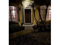 Home's inviting entryway with a decorative door, sidelight windows, and lush landscaping at 4920 E Lake Cove Blvd, St Cloud, FL 34771
