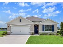 Charming single-Gathering home featuring a two-car garage, manicured lawn, and traditional architectural details at 5133 Masser Rd, St Cloud, FL 34772