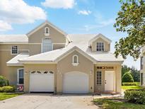 Charming townhouse featuring a two-car garage, well-maintained landscaping, and a bright, welcoming facade at 7021 Della Dr # 51, Orlando, FL 32819