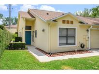 Charming single-story home showcasing a blue front door and manicured landscaping at 711 Swan Ln, Altamonte Springs, FL 32701