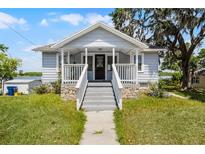 Charming home featuring a welcoming front porch, stone accents and manicured lawn at 730 S Main Ave, Groveland, FL 34736