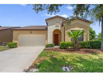 Charming single-Gathering home with a well-maintained lawn, mature landscaping, and attached two-car garage at 1023 Hermosa Way, Kissimmee, FL 34744