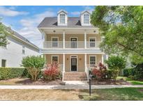 Charming two-story home featuring a welcoming porch, dormer windows and well-maintained landscaping at 1131 Indigo Dr, Celebration, FL 34747