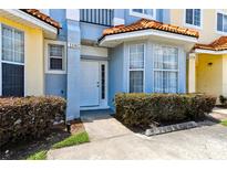 Inviting townhome front entrance with well-maintained landscaping and a charming, light blue exterior at 1180 S Beach Cir, Kissimmee, FL 34746