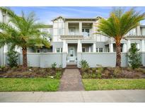 Attractive townhouse with palms, lawn and walkway to the front door at 13437 Granger Ave, Orlando, FL 32827