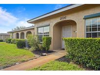 Charming tan home exterior with well-maintained landscaping and an inviting arched entryway at 206 Diamond Cv # 106, Casselberry, FL 32707