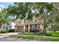 Street view featuring a two-story home with a large front porch and attached garage at 2116 Truffle Ln, Casselberry, FL 32707