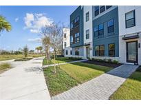 Modern townhome featuring a landscaped yard, neutral colors, and welcoming entryway at 2378 Addalia Aly, Orlando, FL 32804