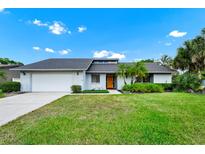 Charming single-story home with a well-manicured lawn and an inviting front entrance with a bright yellow door at 3379 Monika Cir, Orlando, FL 32812