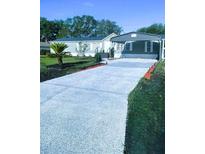 Charming single-story home with a carport, well-maintained landscaping, and a long, patterned driveway at 37518 Quail Ridge Cir, Leesburg, FL 34788