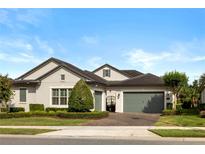 Charming single-story home featuring a well-manicured lawn, gray paint, and a two-car garage at 3883 Grassland Loop, Lake Mary, FL 32746