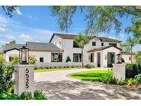 Stunning modern home showcasing detailed landscaping, custom pavers, and sleek exterior accents, perfect curb appeal at 5525 Isleworth Country Club Dr, Windermere, FL 34786