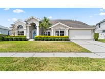 Charming single-Gathering home featuring a well-manicured lawn and a light blue front door with decorative wreath at 633 Lakehaven Cir, Orlando, FL 32828